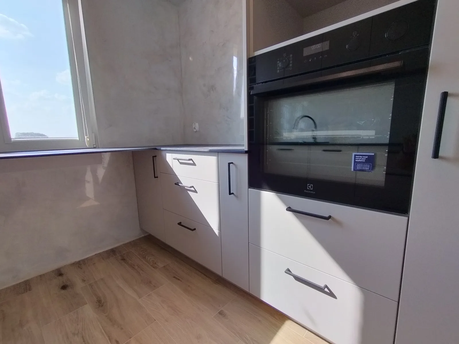 Kuchnia na wymiar w kremie, widok przy oknie