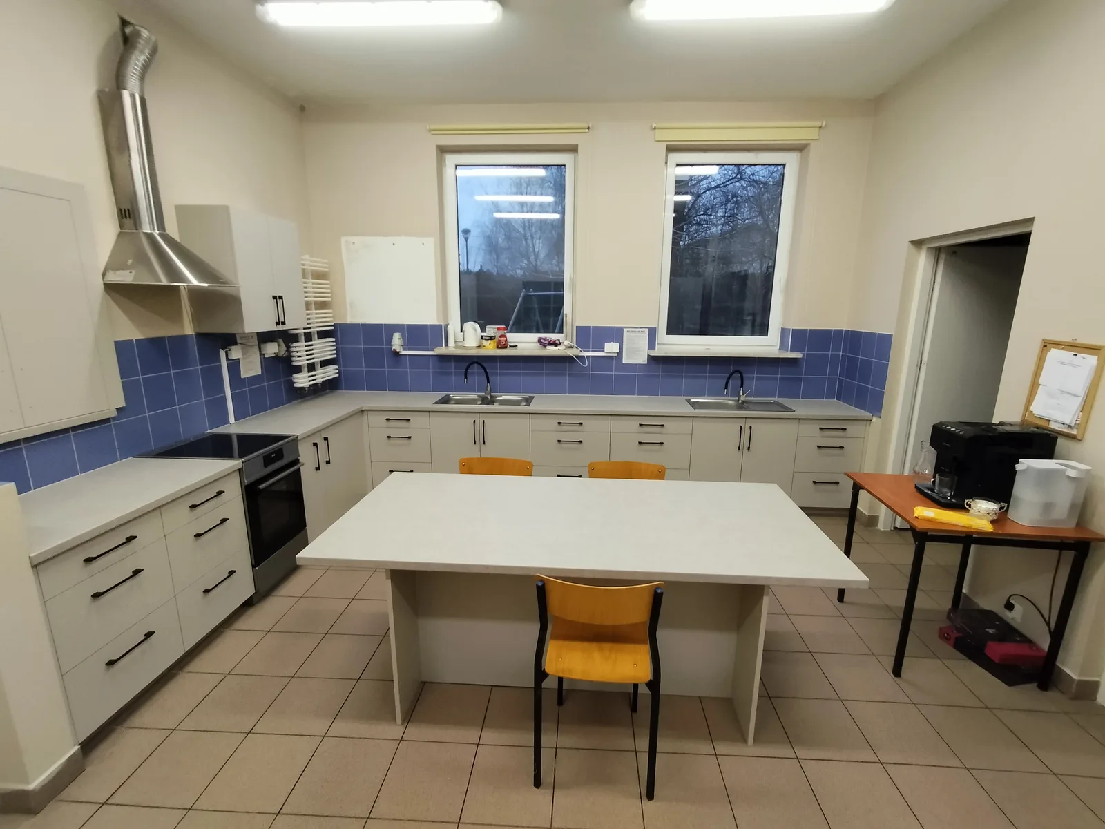 Kuchnia na wymiar z jadalnią, niebieska mozaika na ścianie
