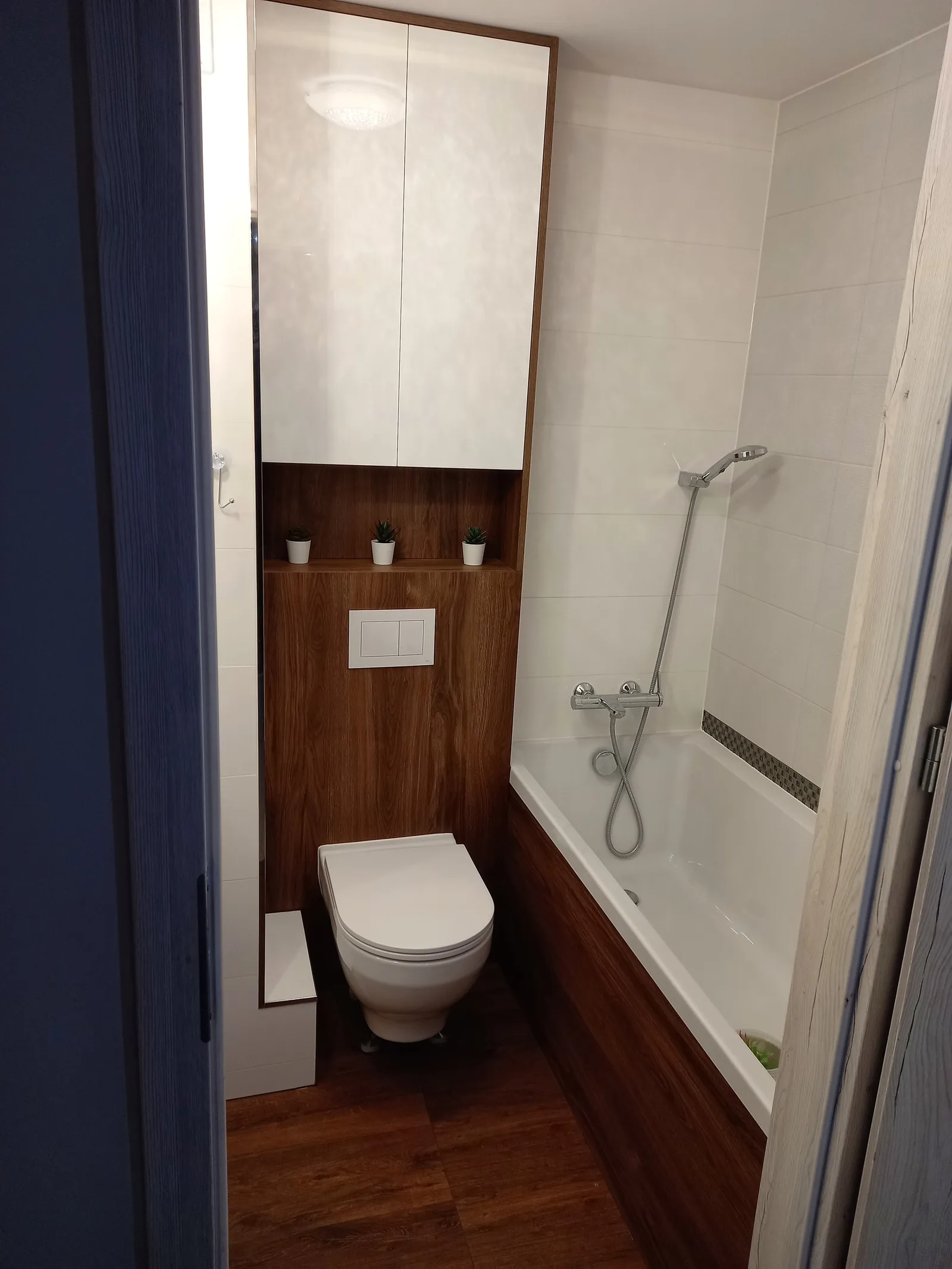 Łazienka na wymiar z zabudową w dekorze orzecha, wanna i WC podwieszane