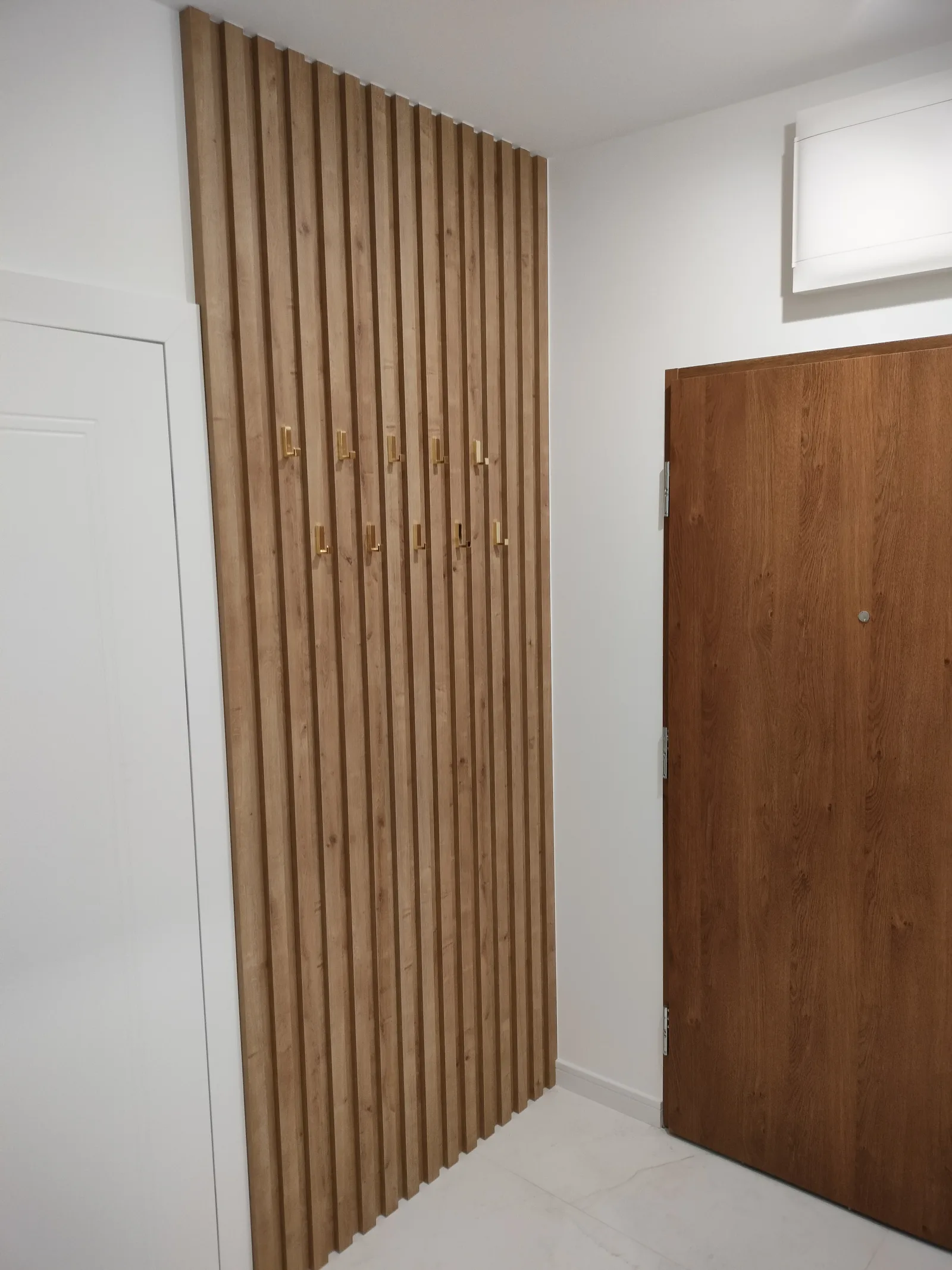 Panel z drewnianych lameli na wymiar w przedpokoju