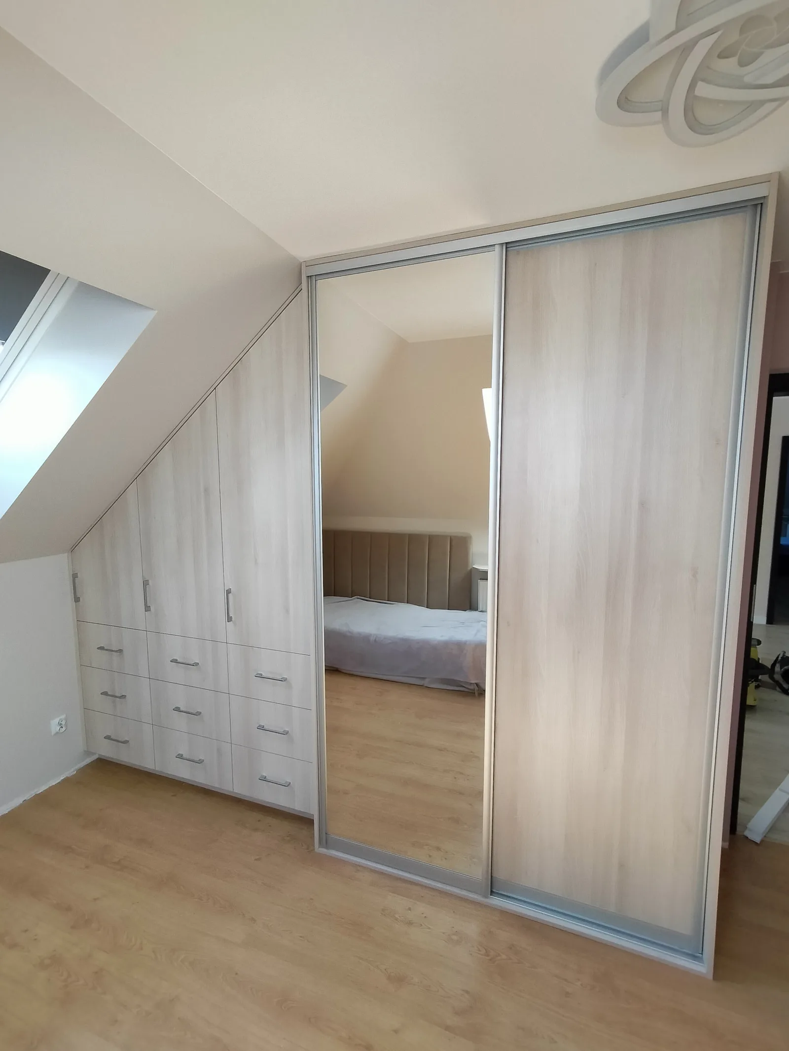 Szafa przesuwna na wymiar z lustrem pod skosem poddasza